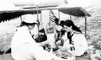 fay_viosca_pics_019 -- The AMOEBA under way. L-R: Villa Viosca helping serve, Unknown woman with left hand on head, Uniknown woman with large white hat, Randall Felix Viosca in back by flag, Unknown man in ranger hat, Harry Viosca? barely visible behind Alice Baudean. (Boat may or may not really be the AMOEBA.)